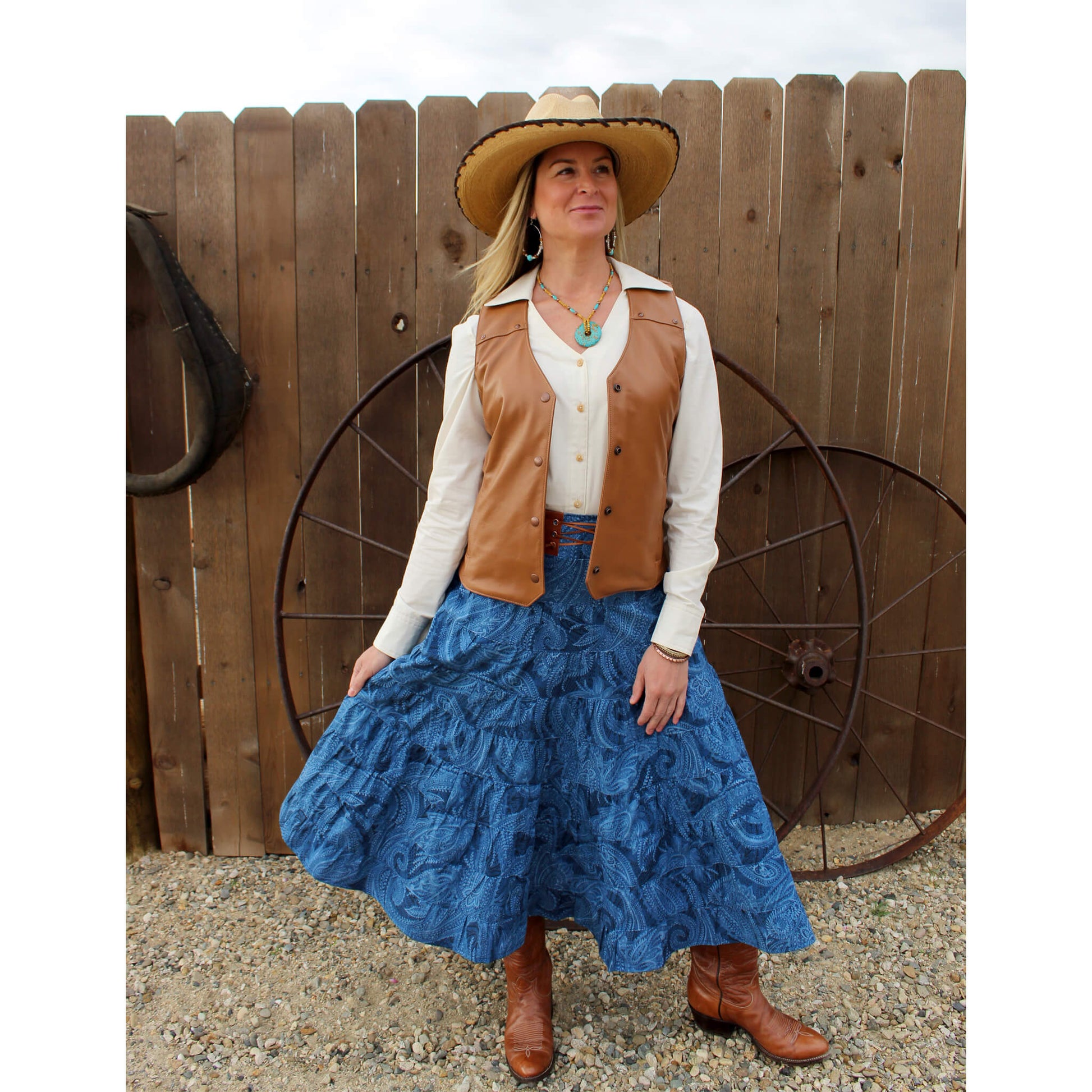 A great western skirt in the traditional "broomstick" style. Nine tiers of a blue on blue paisley print cotton. Features include a comfortable wide waistband with elastic in the back for a nice fit and a decorative leather trim and tie in the front. 