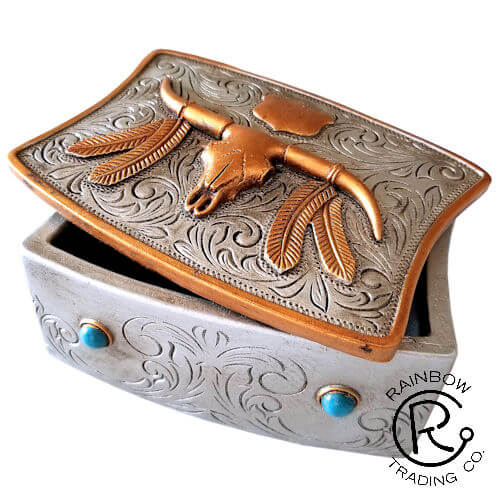 This longhorn trinket box adds a touch of rustic Texan flair to your home decor while keeping your essentials stored neatly away. The richly detailed etching of a longhorn, feathers, and desert landscape pops against the sleek black resin. Lift the lid to reveal the handy divider that helps organize rings, earrings, cufflinks, and more - no more digging to find what you need! An ideal gift for the cowboy or cowgirl in your life.