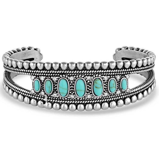 Luckily for you, our Lucky Roads cuff bracelet is incredibly versatile and easy to wear. From its cuff style to its gorgeous turquoise stones, it's a wonderful way to personalize any outfit. This silver tone cuff has raised beading trim that perfectly outlines seven oval turquoise stones for a symmetrical and elegant design. Wear it alone or pair it with other pieces to create a signature look. Silver over brass. Synthetic turquoise. Paint