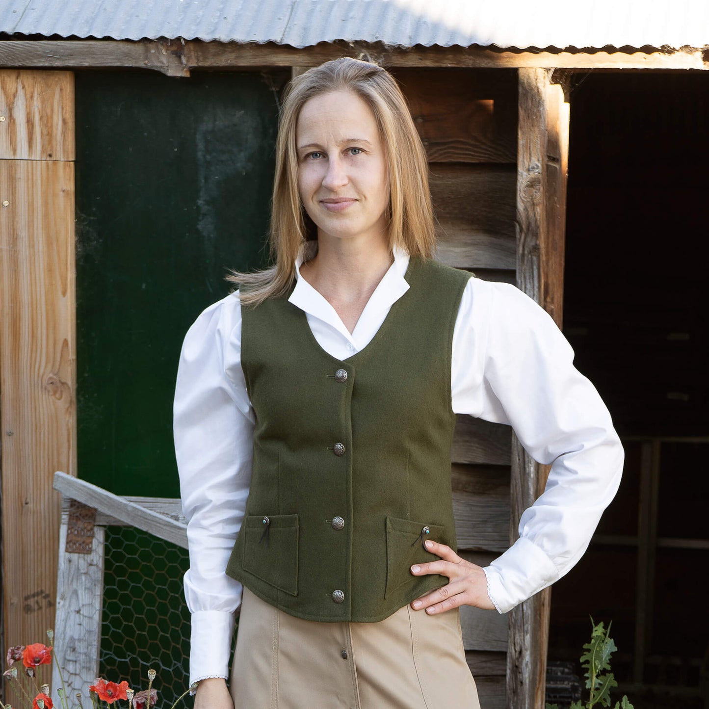 Every western closet needs a western vest and yours needs this one. Antiqued-Nickel Concho buttons (matches our Maybelle Gore Skirt) make a beautiful statement on warm olive or rich-rust colored 100% Melton Wool. Slightly smaller Conchos with a turquoise centered stone wrapped with a leather lace give the final touch to the slightly angled pockets. Adjustable belt in the back for a comfortable fit. Lined in Polyester. Dry Clean Recommended. Made in USA.