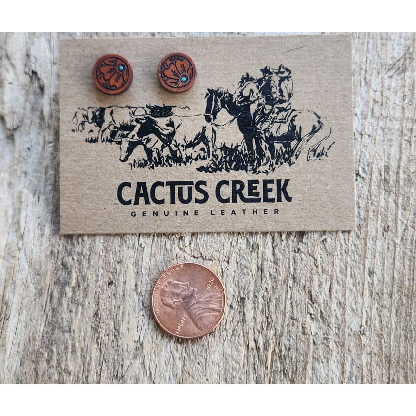 Cactus Creek leather earrings on a wooden surface with a card displaying the brand name.