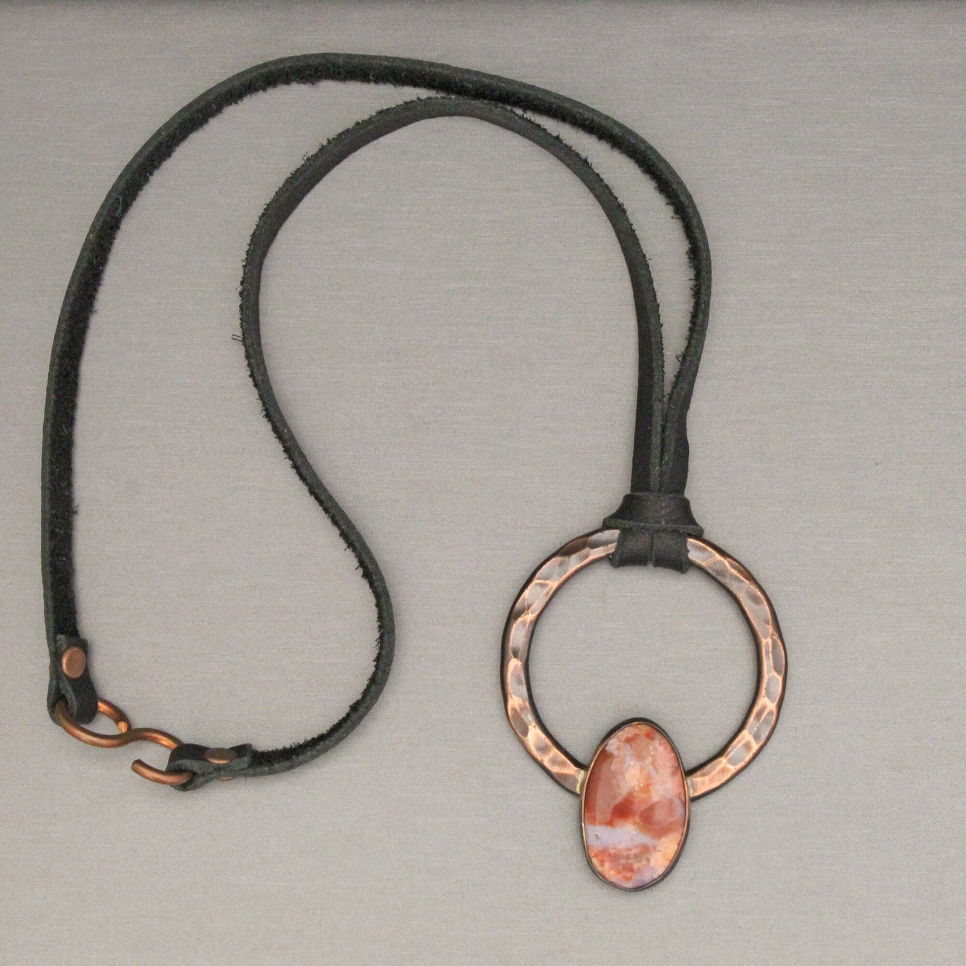 Necklace with a copper pendant on a gray background