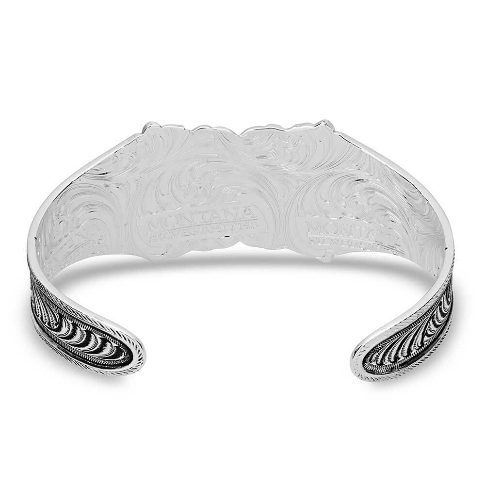 Silver bracelet with intricate designs on a white background