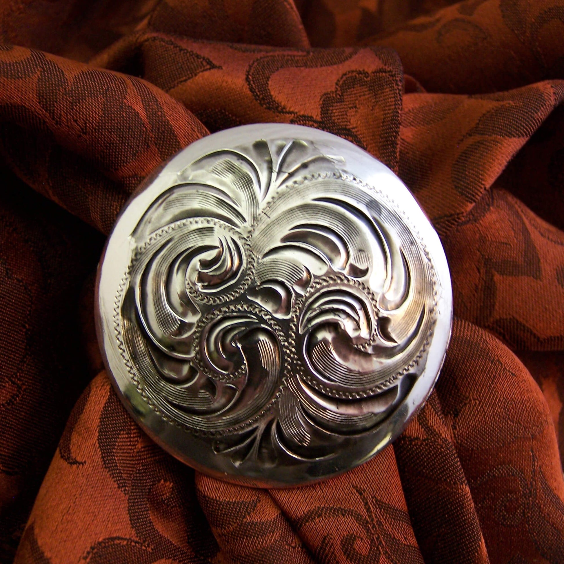 Vintage scroll floral design on a round round scarf slide with Western Look. Measures 1-1/2" diameter.