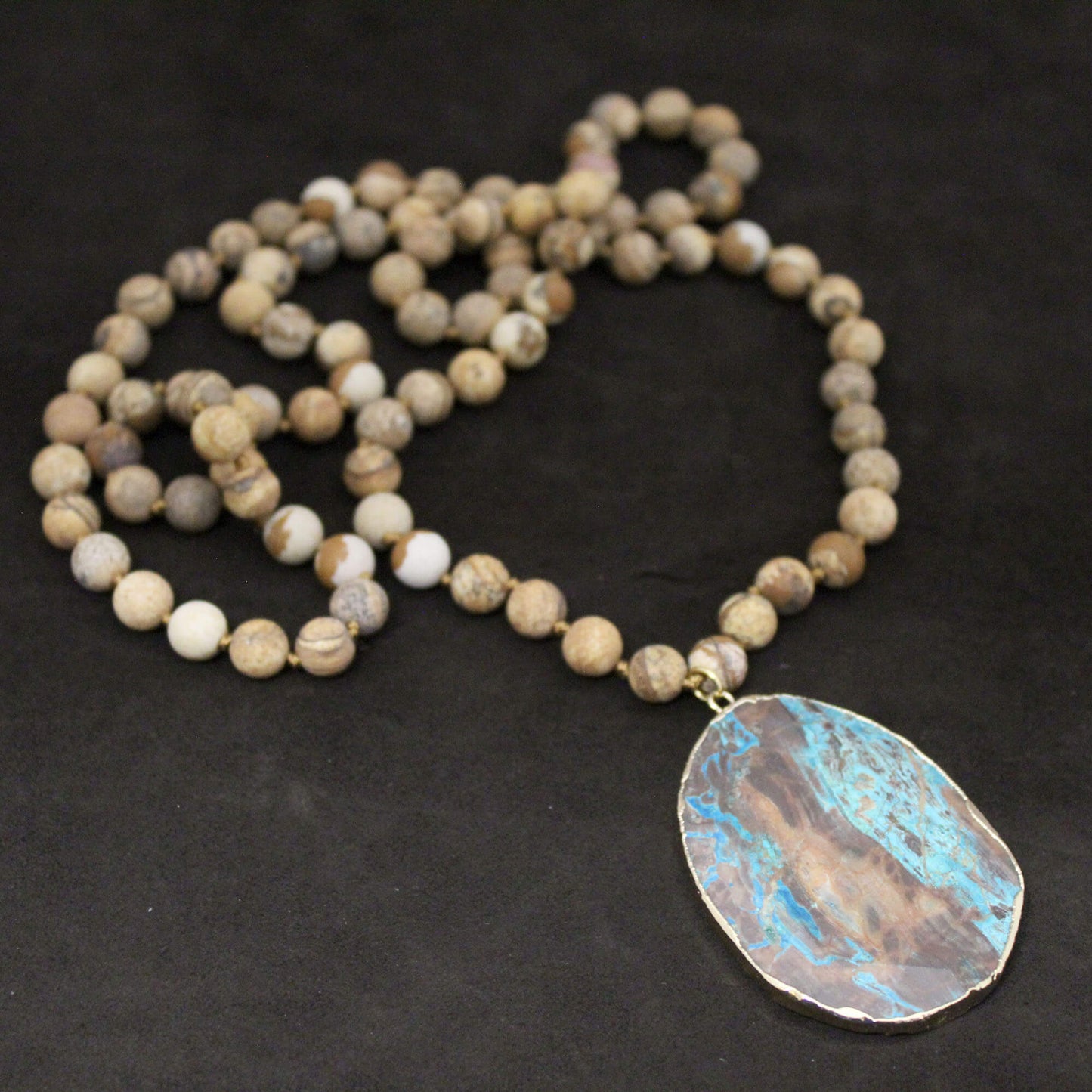 This genuine picture jasper stone necklace is accented with a genuine ocean agate pendant. Perfect item to layer with shorter necklaces. 36" in length. Pendant is approximately 2 ".