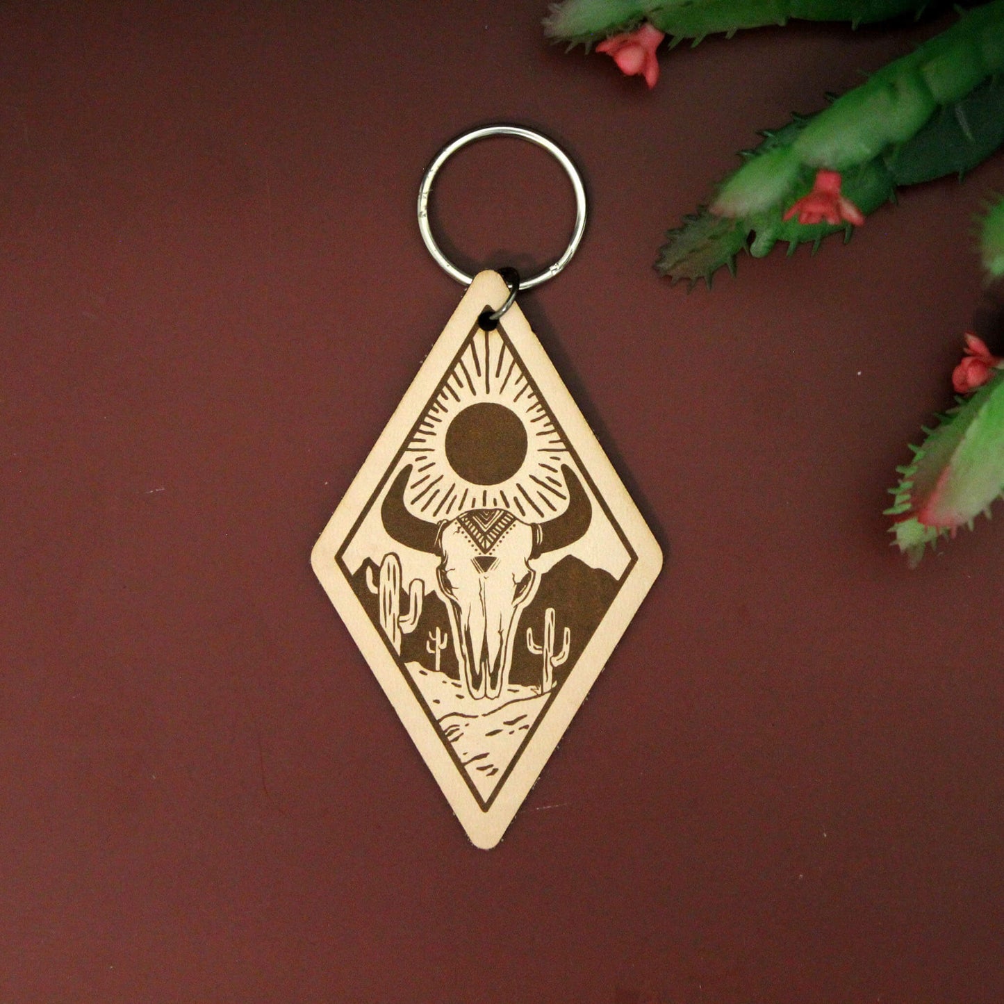 Add a touch of rugged adventure to your keys with the Old Skull Valley Keychain. This unique diamond-shaped leather keychain features a hand-painted skull set against a desert landscape, bringing a bit of the Wild West wherever you roam.