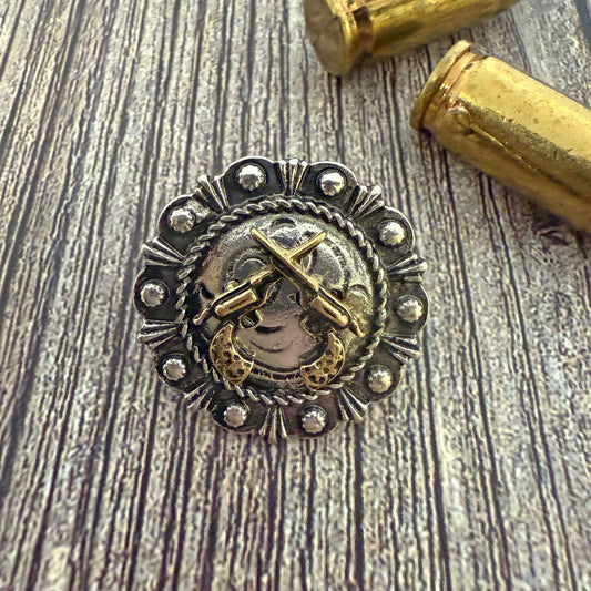 Silver and gold decorative object with a cross on a wooden surface