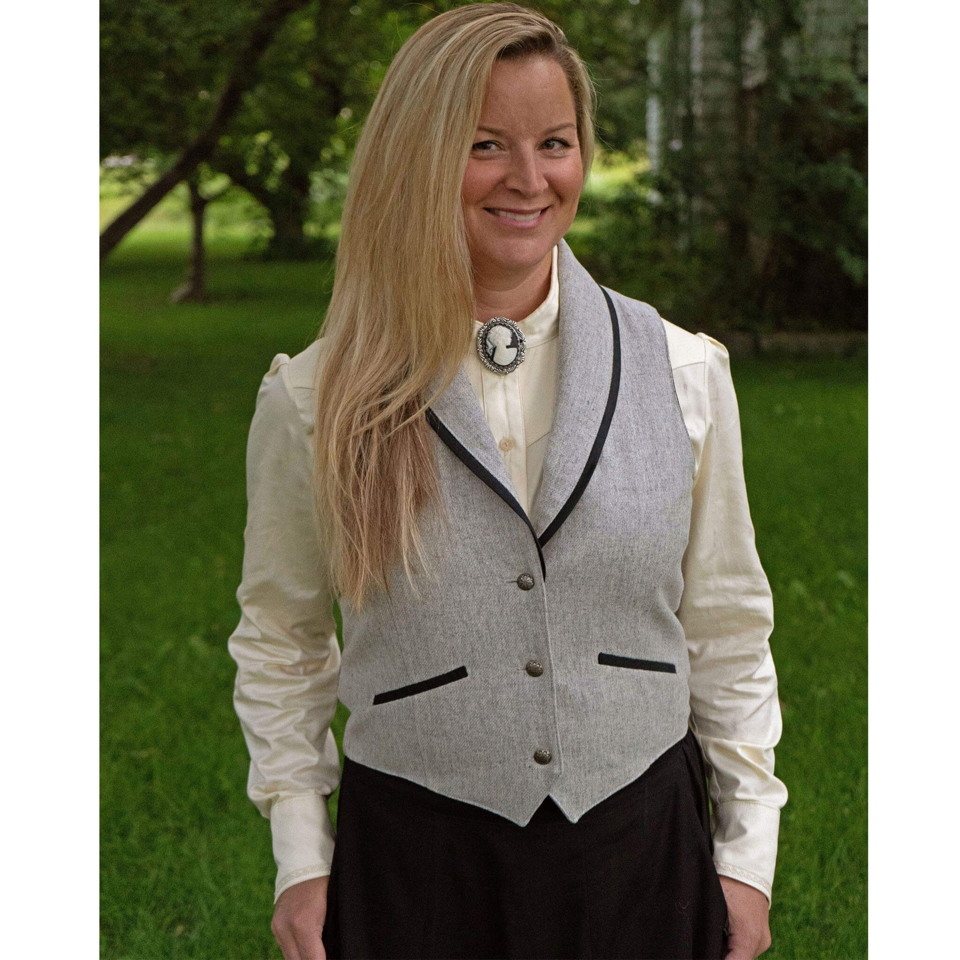 Dress up a nice pair of pants or skirt with this classy Cattle Kate Vest. Black cotton sateen trims the shawl collar that hugs the neckline and adds an interesting contrast to the light heather grey wool. Sateen trims the welt pockets and back belt as well. 100% Wool lined in Polyester. Dry Clean. Made in USA.