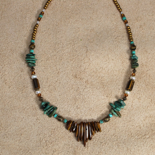 Tiger Eye spikes with mag turquoise ships and pearls, make this an interesting combination. Measures 22″ including a 4″ extender and lobster claw clasp. Each piece is unique and may vary slightly.