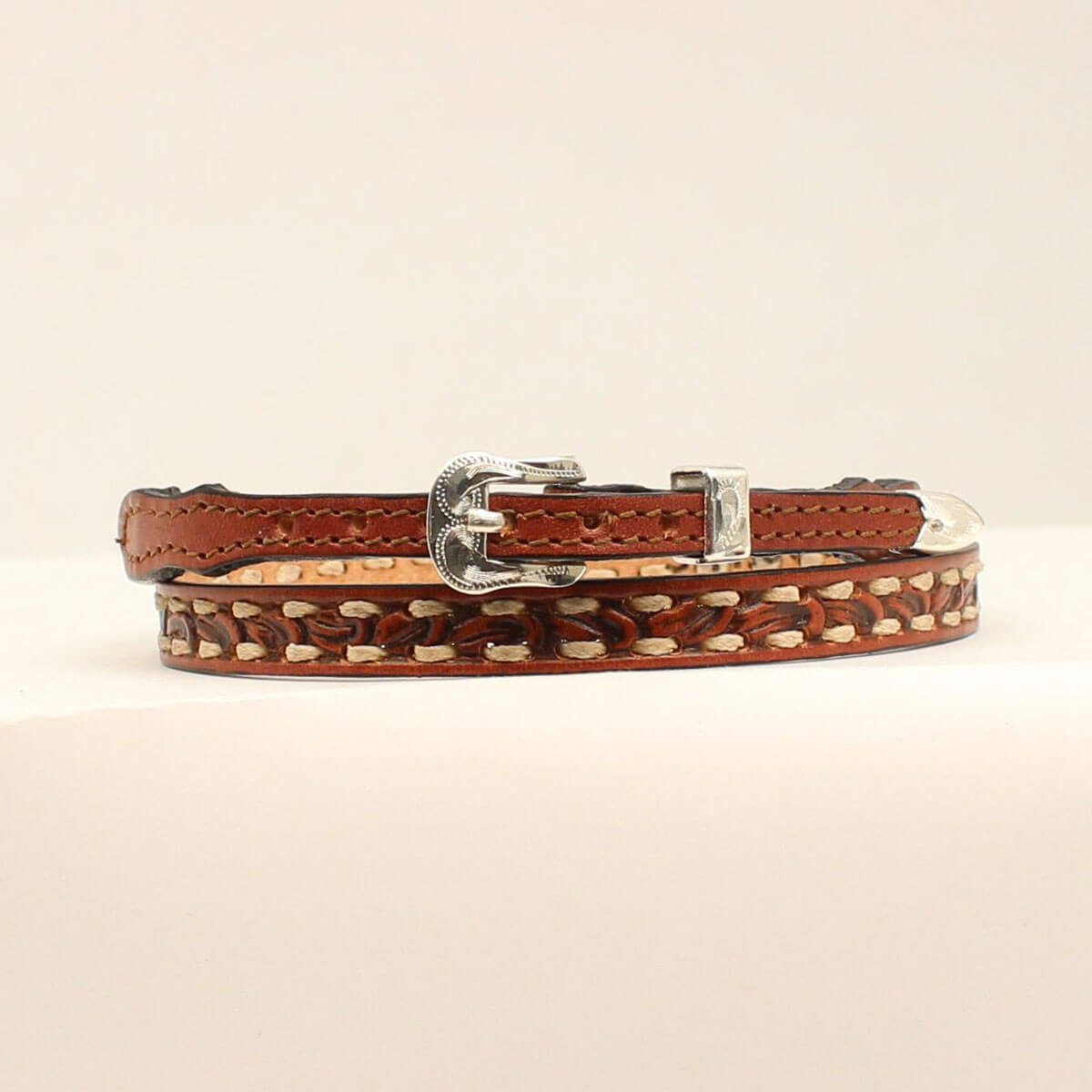Brown leather cowboy hatband with a decorative buckle on a white background