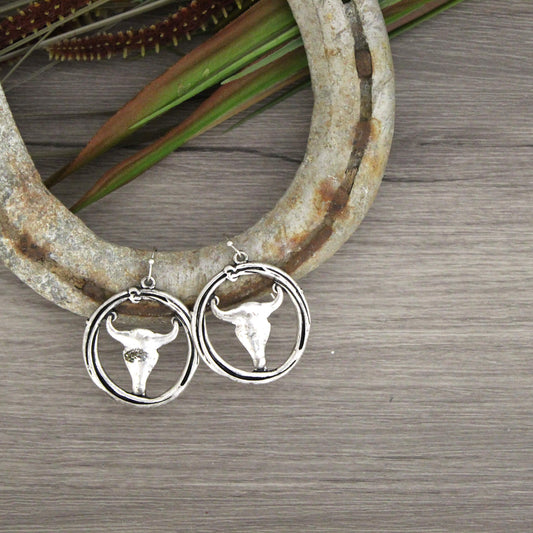 Great looking silver earrings with longhorn design. These cow skull earrings give a western flare to any outfit. Skull hoop earrings feature a hoop-shaped designed like a roping rope with a skull charm hanging inside. 1-1/8" diameter. Hypo-allergenic wire hooks.