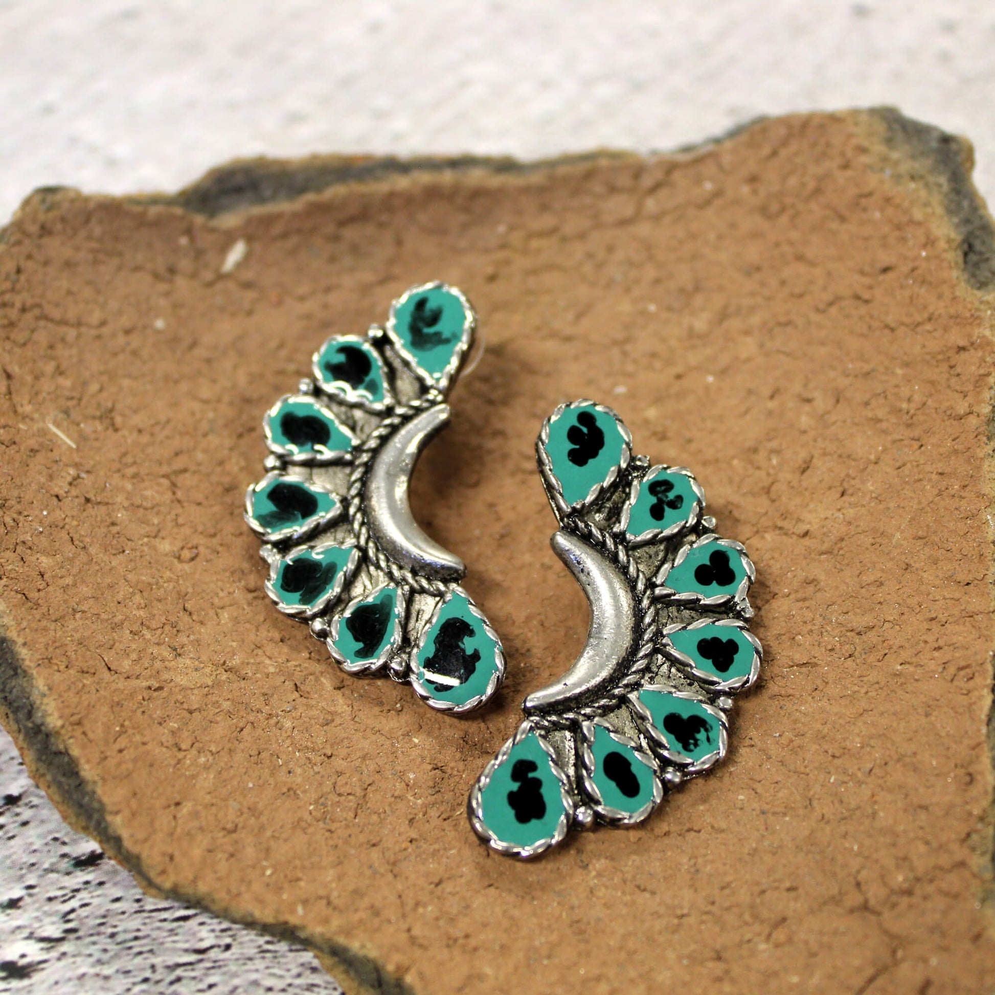 With their bold turquoise, black, and silver color combo, these earrings make a stylish statement with any outfit. The trendy western design gives your look a touch of cowgirl flair, while the classic silver and turquoise stones ensure you'll reach for these earrings for years to come. Measure 2" long by 3/4" wide.