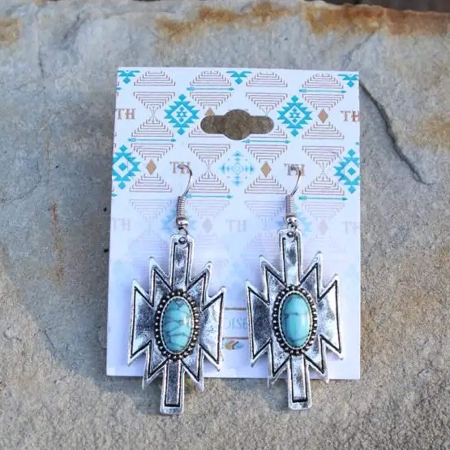 Silver Aztec earrings with a turquoise stone inlay. Cowgirl western earrings that will go with so many outfits, it will be a go to in your collection. Measure 2" long by 3/4". Made in USA