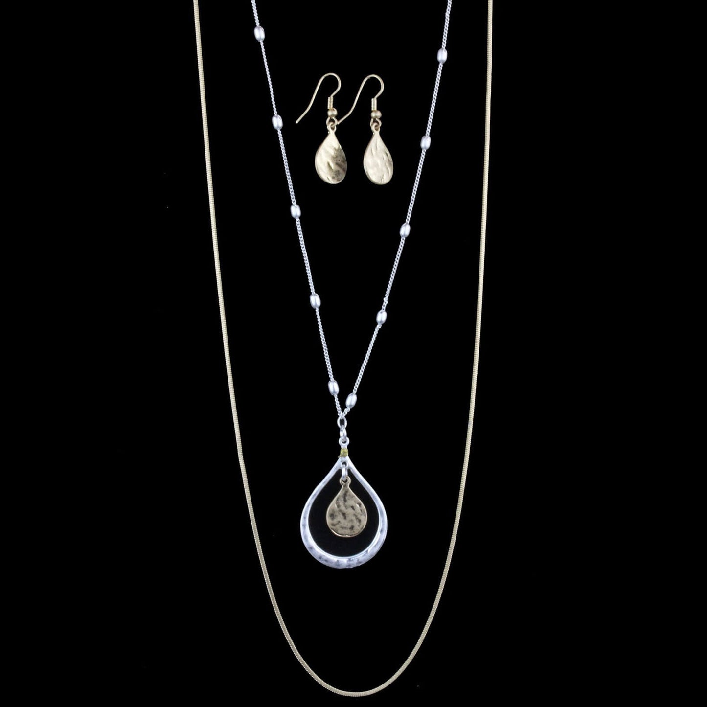 Classic Simplicity in layers! Two snake chains in brushed silver and gold. Necklace measures 20.5″ with lobster claw clasp and extension chain. Comes with matching teardrop earrings on hypoallergenic ear wires.