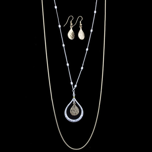 Classic Simplicity in layers! Two snake chains in brushed silver and gold. Necklace measures 20.5″ with lobster claw clasp and extension chain. Comes with matching teardrop earrings on hypoallergenic ear wires.