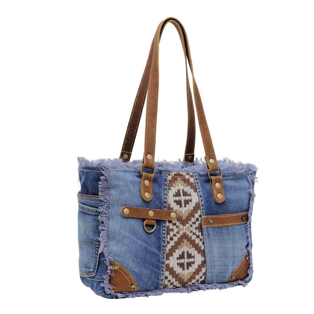 The canvas print center adds a pop of playful pattern too. Whether you're a modern cowgirl or just love that western aesthetic, this denim bag makes the perfect accessory. Simply sling it over your shoulder with your favorite jeans and boots or floral dress for an instant style upgrade. Yeehaw! Measures 13.5" x 9.5" x 5.5" Made in India.