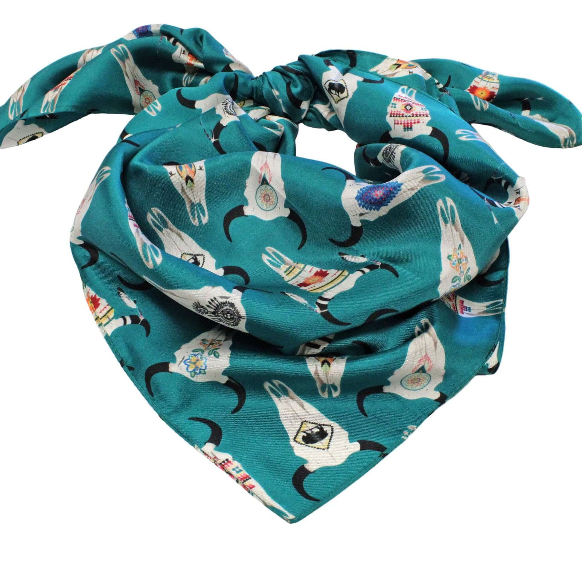 Teal scarf with cow skull pattern on a wooden surface