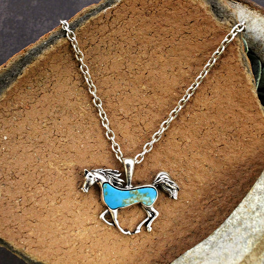 A stunning piece of jewelry that features a horse pendant adorned with stone inlay. This necklace is designed to reflect the beauty and strength of the horse. The Stone Horse Necklace is perfect for anyone who loves horses or appreciates the rugged, natural beauty of the American West.