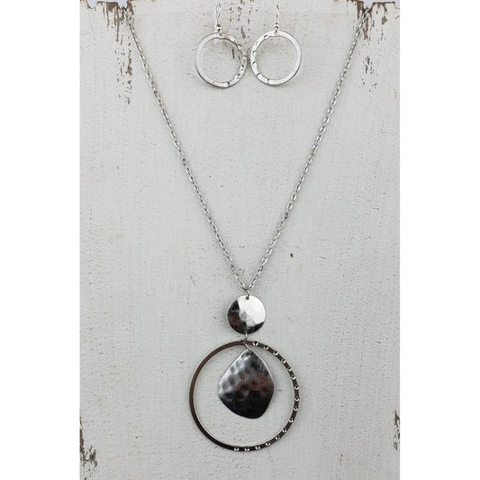 A long silver set just for you. Hammered circle with a plate dangle center hangs below a silver tone disk on a large link silver tone chain. Necklace measures 28″ with lobster claw clasp and extension chain. Matched with hammered hoop earrings on hypoallergenic ear wires.