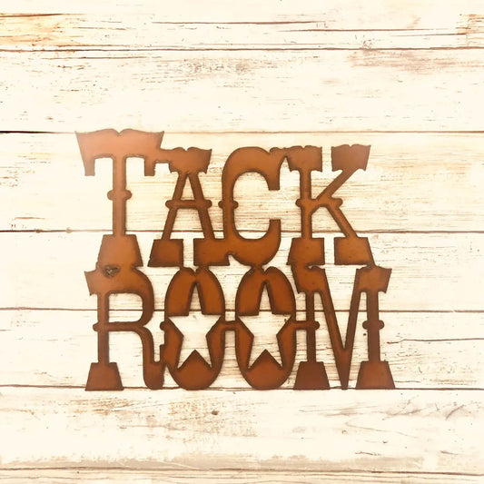 Copper-colored metal wall art spelling 'TACK ROOM' in a rustic western-style font, displayed on a light wood plank background.