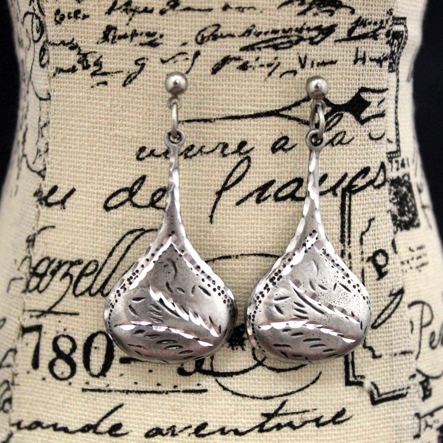 These exquisite earrings are hand-cast in pewter, then finished and polished by hand to a gleaming luster. Each piece is hand diamond cut for that brilliant sparkle, therefore no two pieces are ever identical. Each pair of teardrop pewter earrings measures 1-1/2" long by 1" widest part. Made in USA