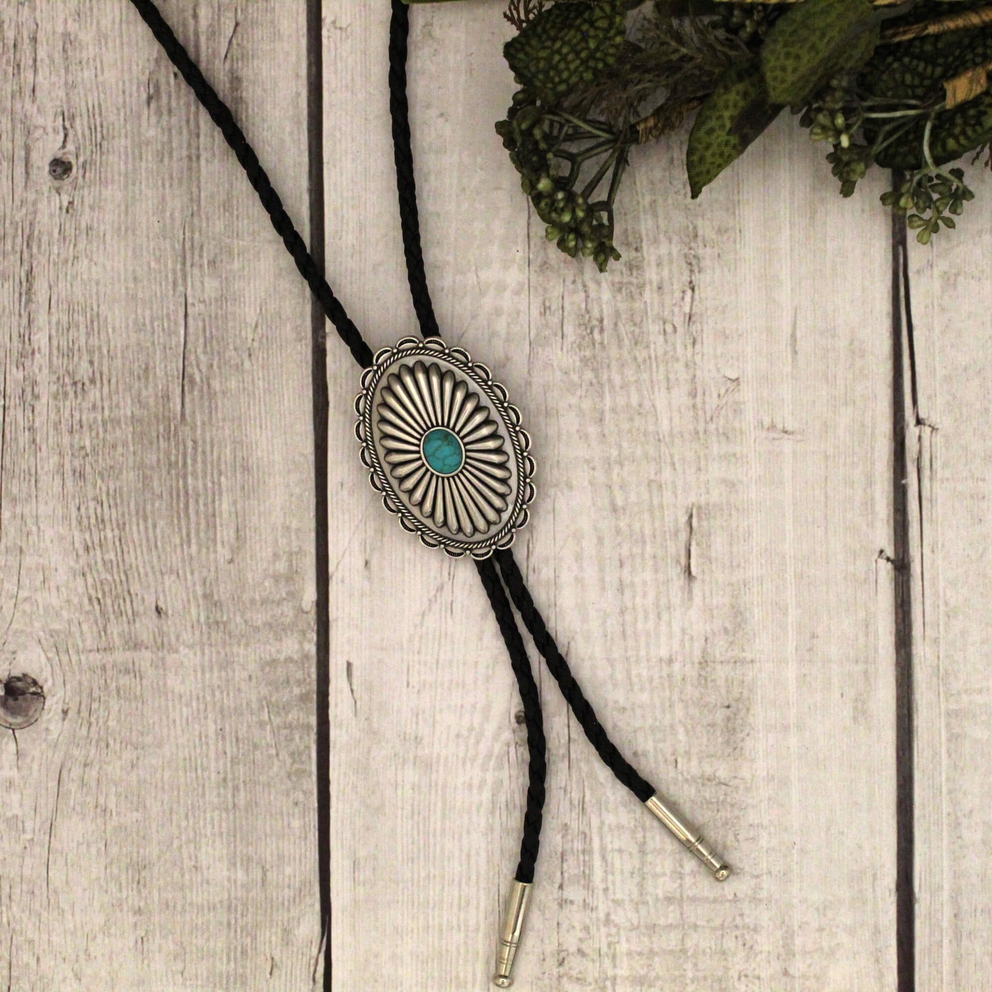 Whether you're attending a formal event, going out with friends, or just running errands, the Tennessee Turquoise Bolo Tie will instantly upgrade your look. It's the perfect choice for the individual who loves to make a statement with their style and isn't afraid to stand out from the crowd. Great for men or women. 36" black cord with concho measuring 1.75" wide by 2.25 long. Made in Taiwan