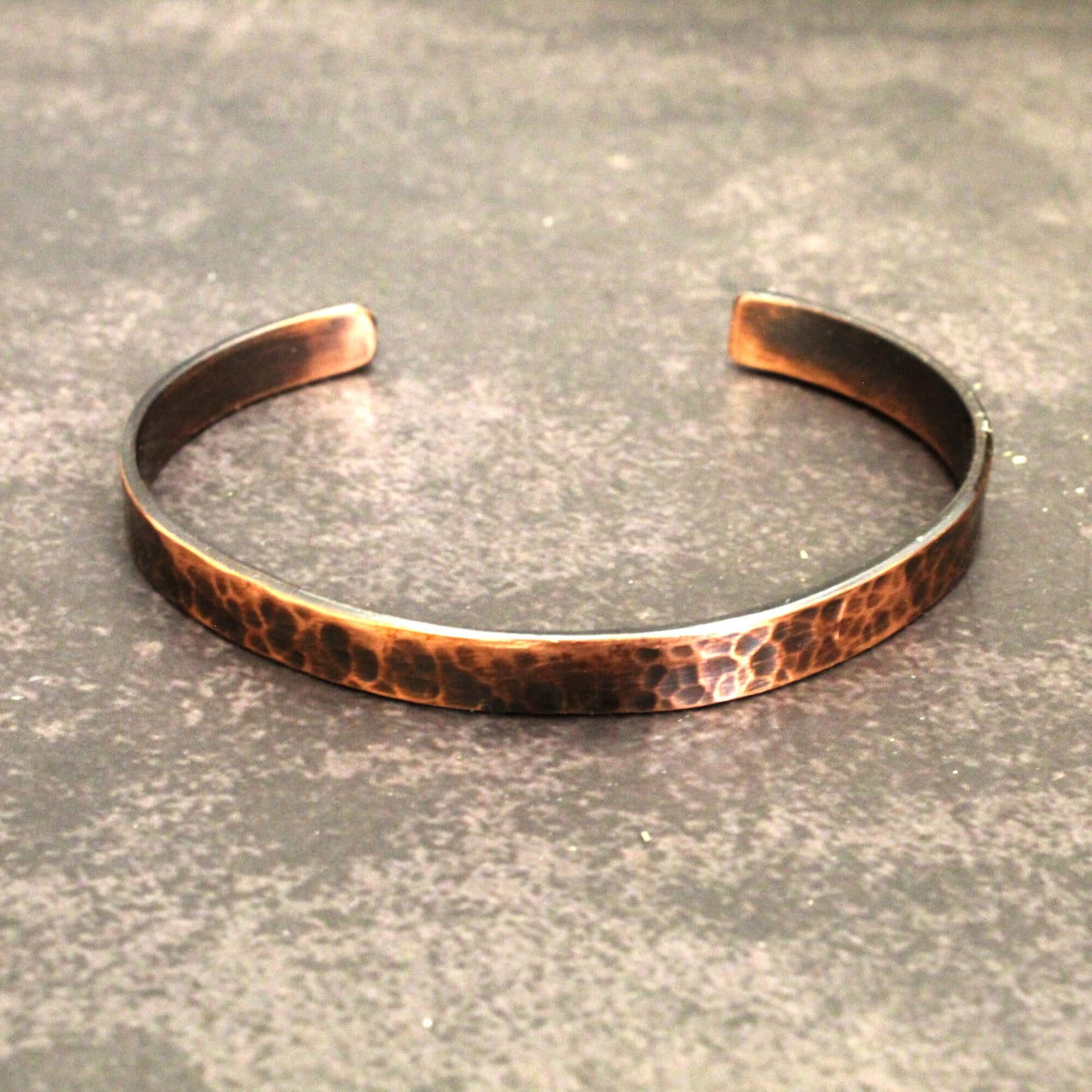 Copper bracelet on a textured gray surface