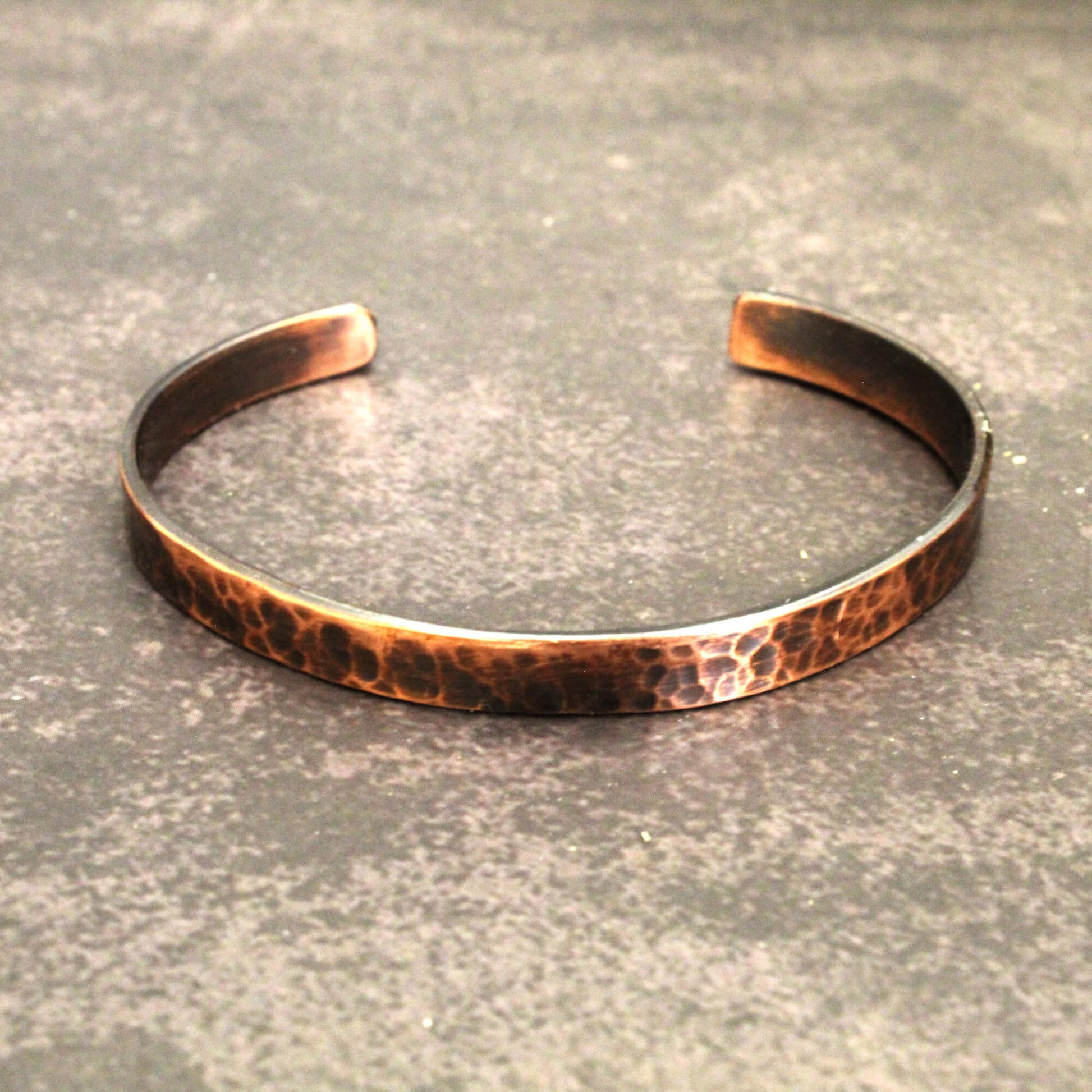 Copper bracelet on a textured gray surface