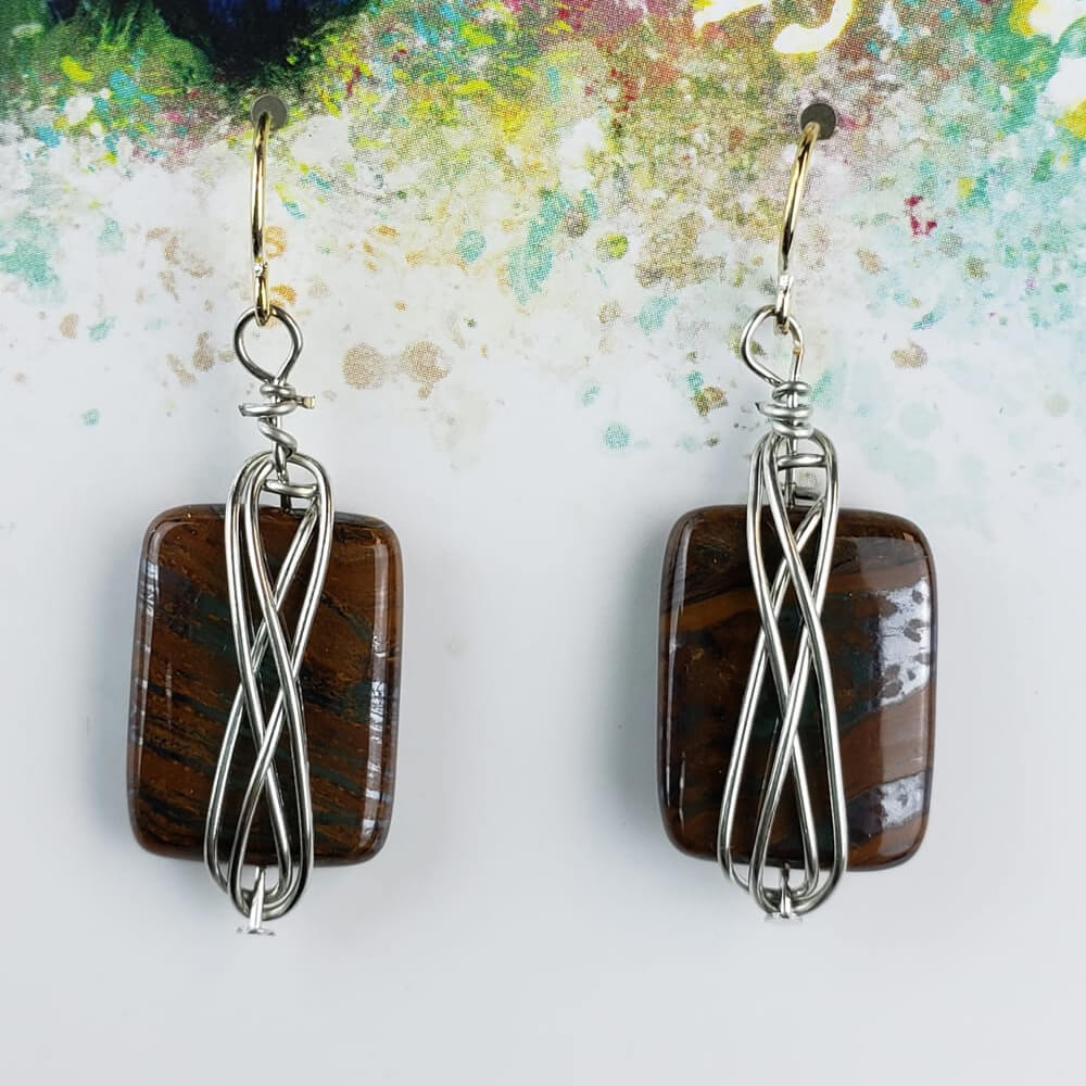 Tiger-eye cabochon. The gold hypoallergenic ear wires extend down to silver wire wrapping around a tiger-eye cabochon. Measures 1″ from bottom of ear wire to bottom of tiger-eye stone.