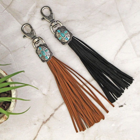 Add a touch of western flair to your getup with our leather tassel. Cute western Concho with turquoise accents on long faux leather &nbsp;fringe about 5" long. Attach to a zipper pull, decorate purse, planner, journal or diaries and many more. Tassel is fitted with a lobster clasp. It can easily be attached and can be moved around and removed with ease.