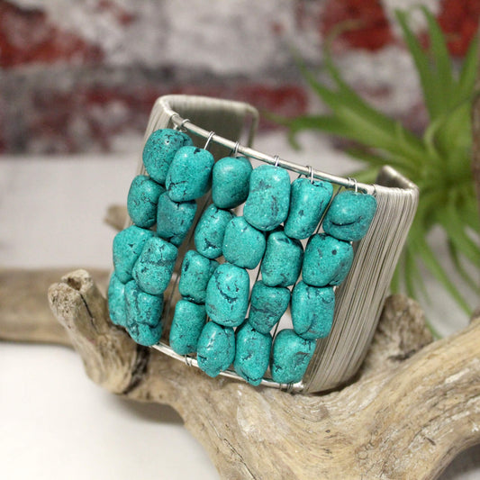 Make a bold statement with the Turquoise Clip Cuff bracelet. This stunning cuff features a thick silver band wrapped in fine wire and rows of chunky genuine turquoise stones for an eye-catching pop of color.