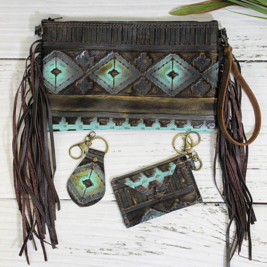 Measuring at 6” x 9”, this clutch offers enough space to carry everything. Made with genuine leather, this gorgeous, one-of-a-kind clutch is unlike any clutch you’ve seen before. Handmade in the state of Texas, each clutch that we design is entirely unique! So, while the clutch that you receive will look similar to the one in the picture, no two purses sold are identical. Fully lined with a zipper closure. Clutch includes two matching accessories. A small card holder and keychain.&nbsp;