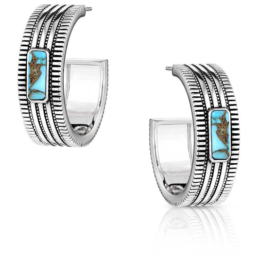 Silver hoop earrings with turquoise stones on a white background