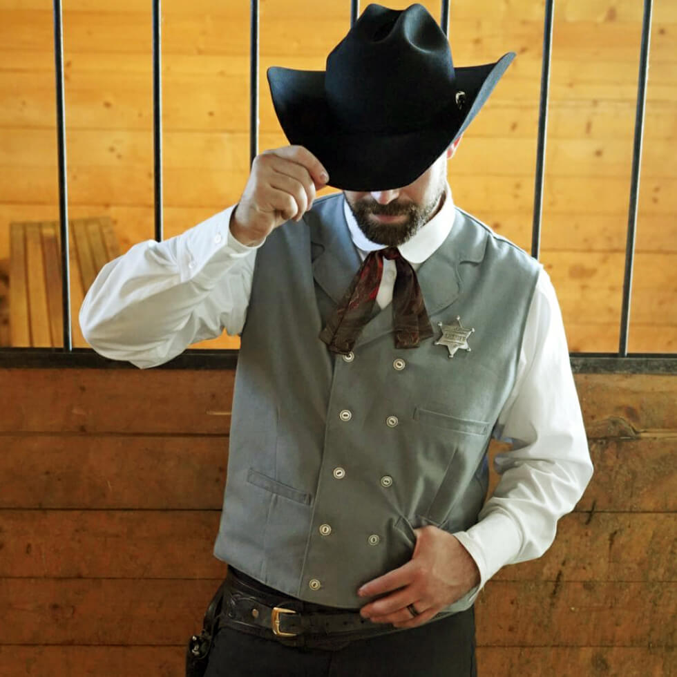 This handsome double-breasted vest features notched lapels and welt pockets with two striking rows of metal buttons. Made in a neutral tone cotton canvas, lined in polyester. Has an adjustable back buckle to match the metal front buttons. Made in USA.