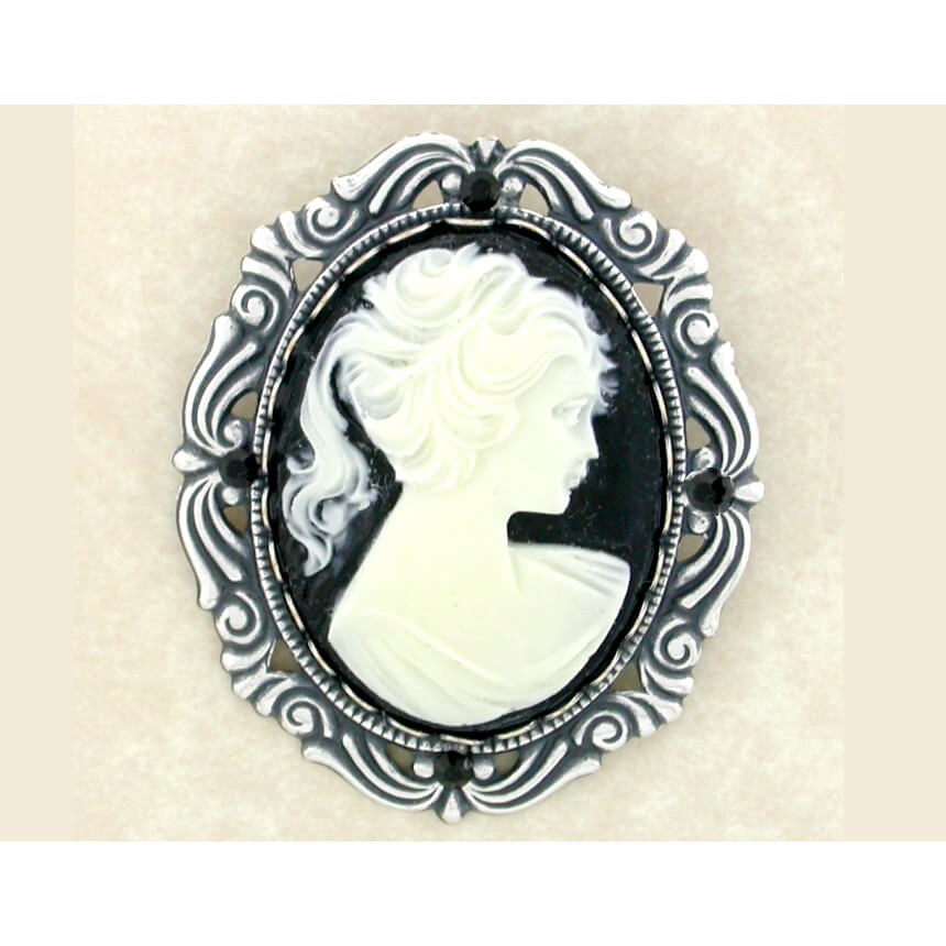 Cameo brooch with black and white design on a beige background