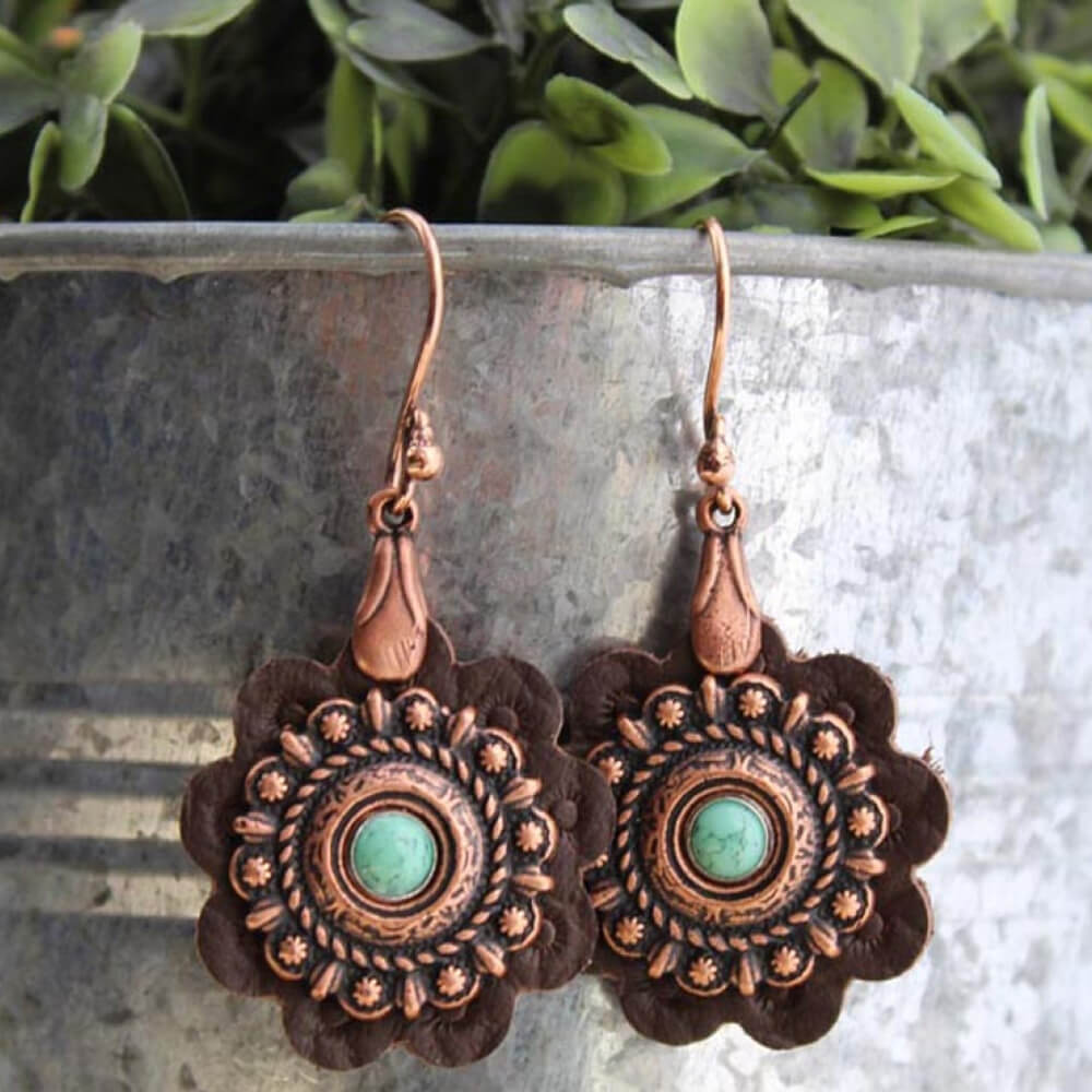 When you want jewelry that is as unique as you are, look no further than these hand cut leather rosette earrings. The brown leather is decorated with a copper Concho and turquoise center hanging from a copper wire hook. Approximately 1” diameter. 