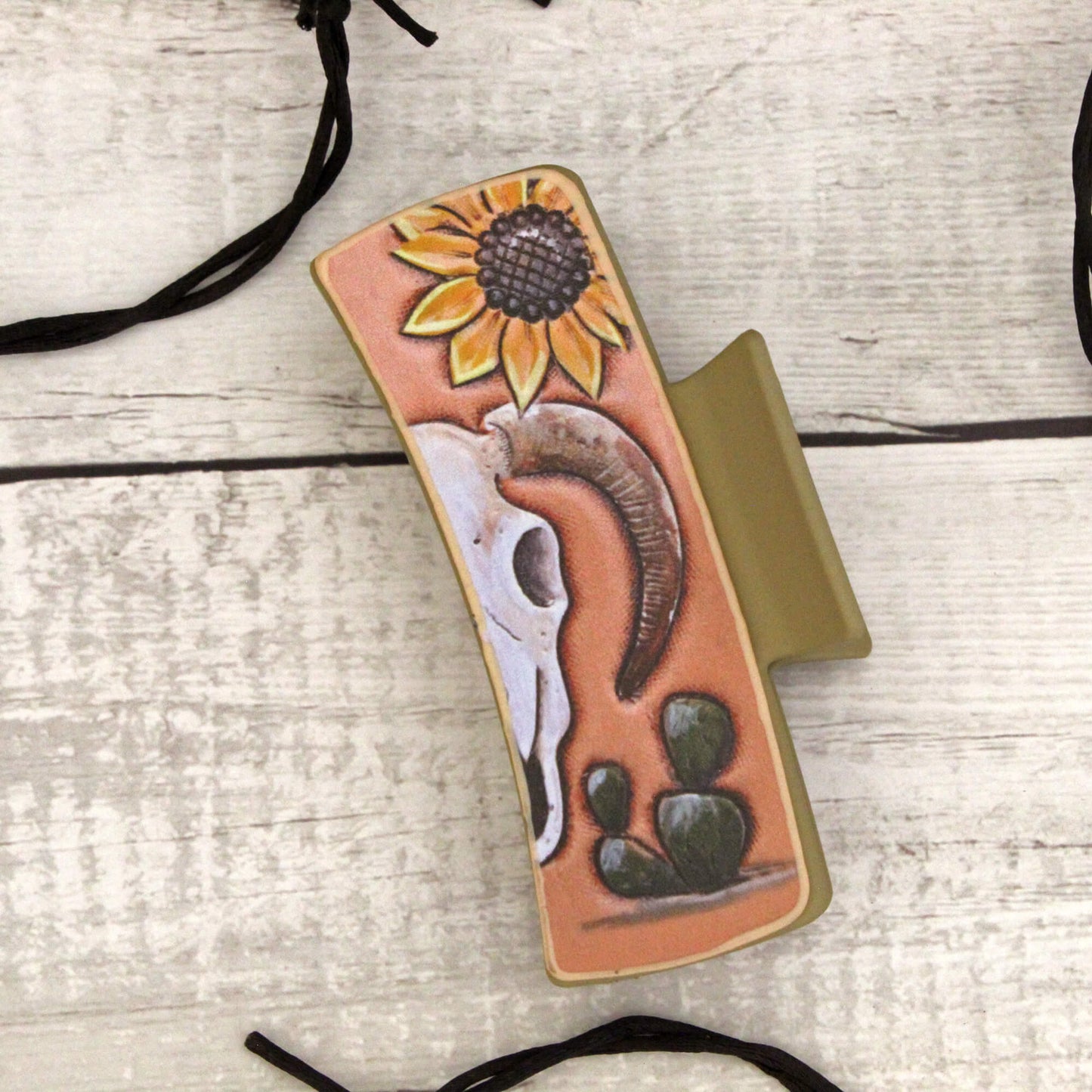 Phone case with sunflower and Cow skull design on a wooden surface
