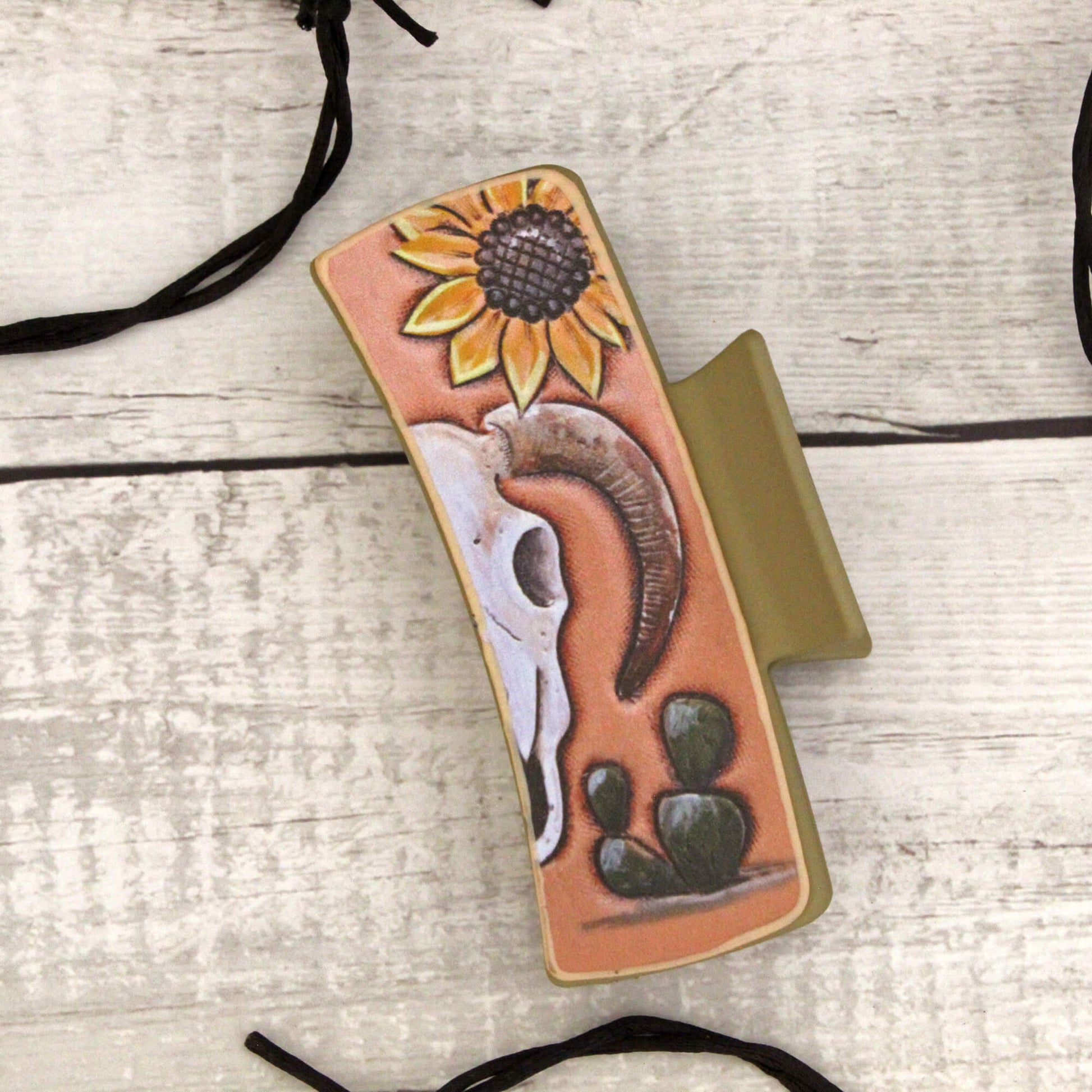 Phone case with sunflower and Cow skull design on a wooden surface