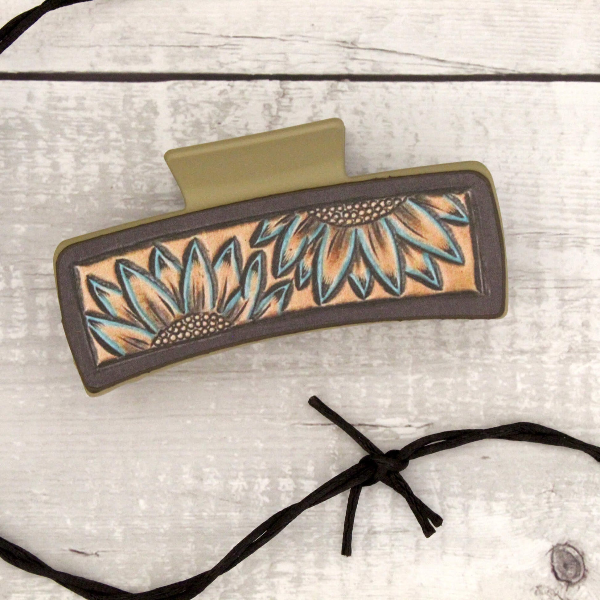 Decorative hair clip with sunflower design on a light wooden background