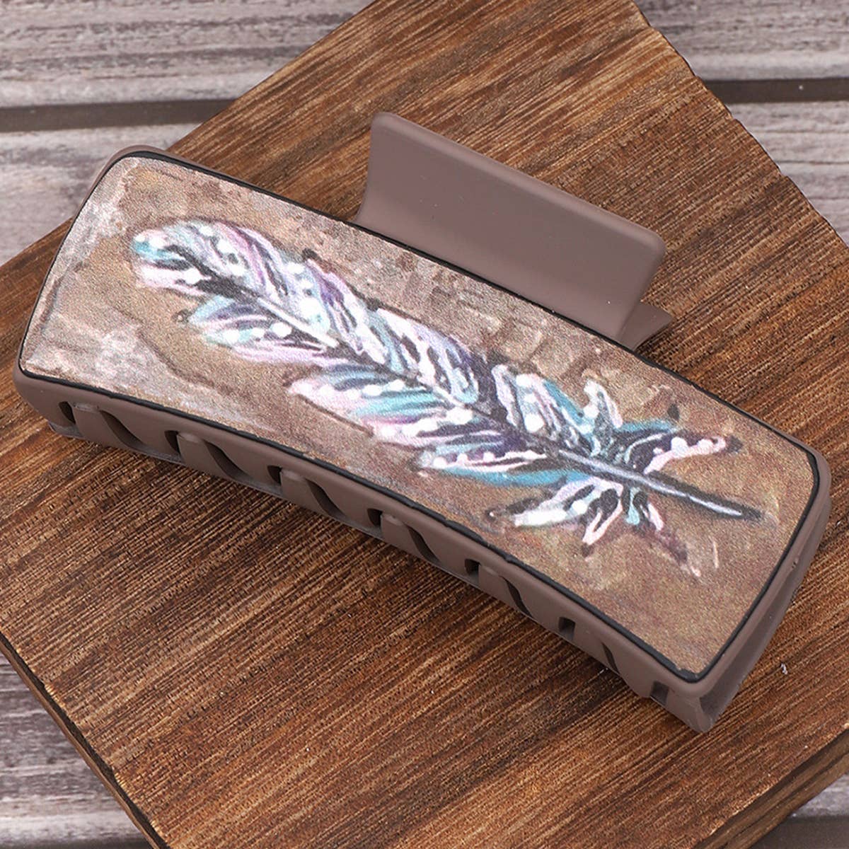 Hair Clip with feather design on a wooden surface