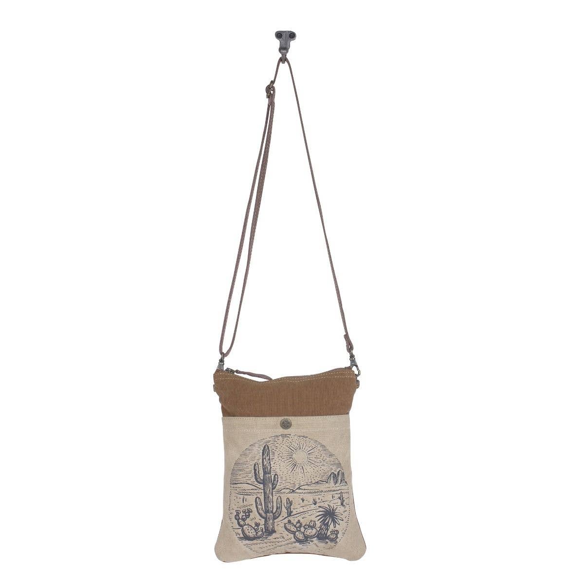 Crossbody bag with desert scene design on a beige background