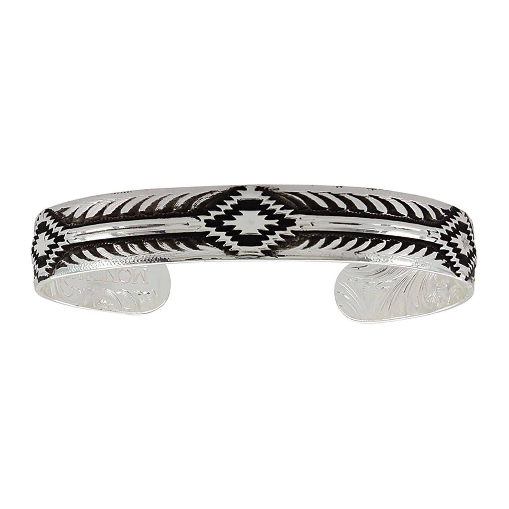 A thinner silver finished cuff bracelet with a hand painted background emphasizing the Aztec inspired step-like main pattern. Approximately .5" wide. Made in USA