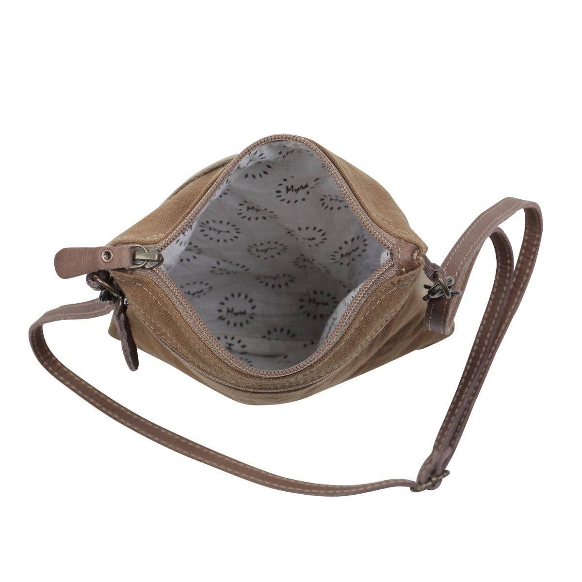 Brown leather crossbody bag with patterned interior on a white background