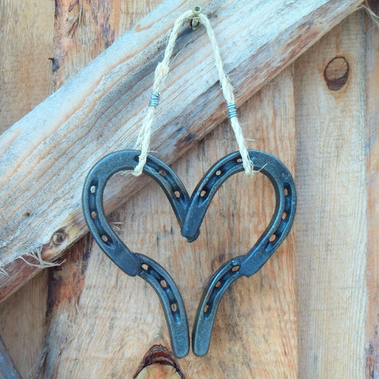 Welded Lucky Western Horseshoe Hanging Heart on rustic wooden background.