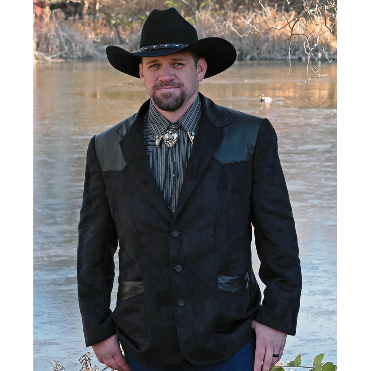 This western Blazer is our latest design in men’s western formal wear. The Blazer is made with buttery soft micro-suede fabric with contrasting genuine leather front and back yokes. The two front inset pockets have yokes accented with contrasting genuine leather for that classic western style. Blazer is fully lined and has an inside chest pocket with center back vent for easy movement. Pairs nicely with jeans or slacks. Dry Clean. Made in USA. 