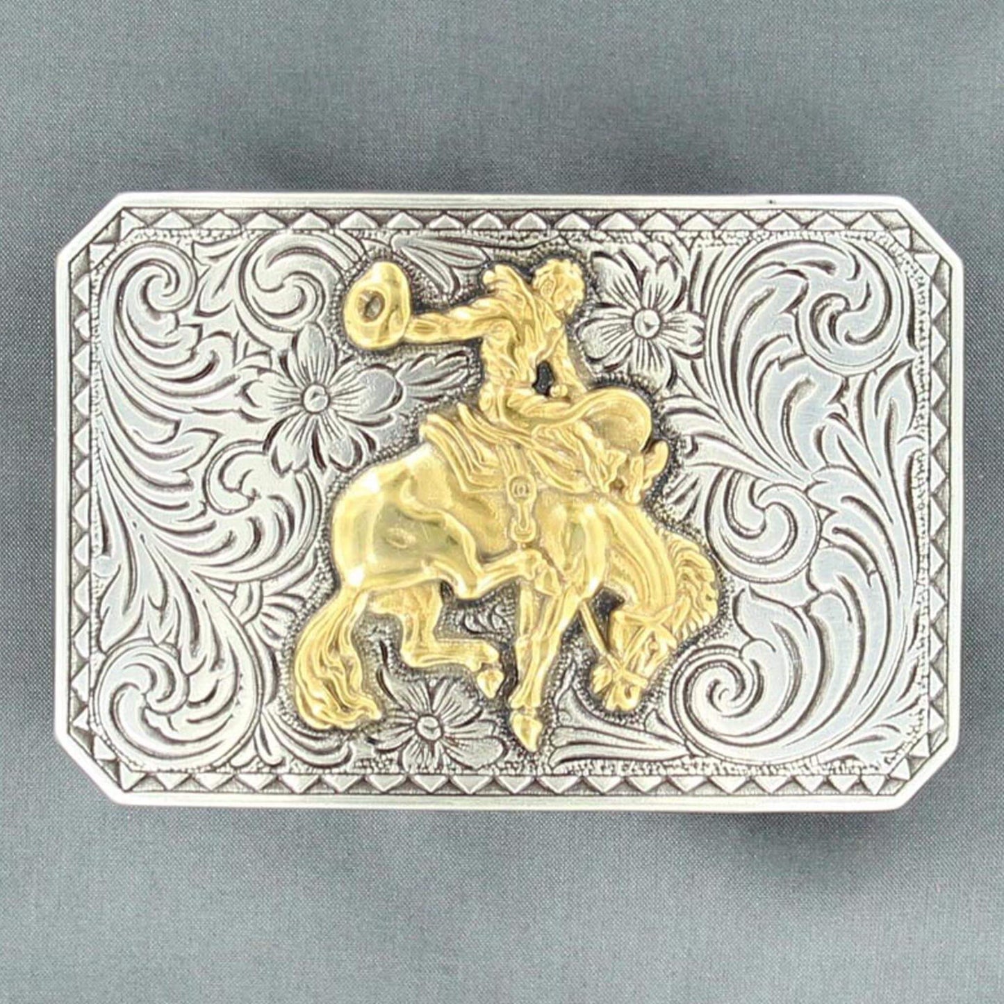 Men's western buckle features a silver floral engraved rectangle shaped buckle with a triangle edge and a gold bucking bronc motif in the center. Measures: 2 X 3. Imported