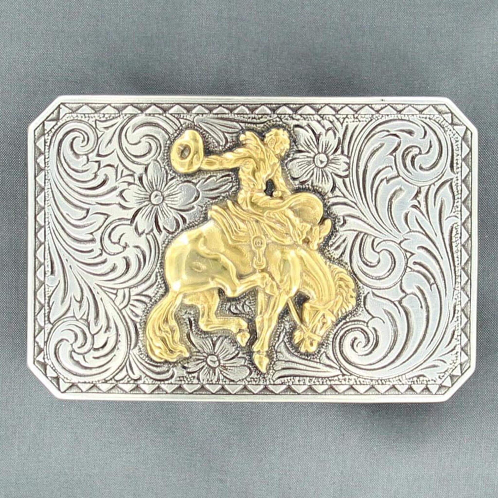 Men's western buckle features a silver floral engraved rectangle shaped buckle with a triangle edge and a gold bucking bronc motif in the center. Measures: 2 X 3. Imported