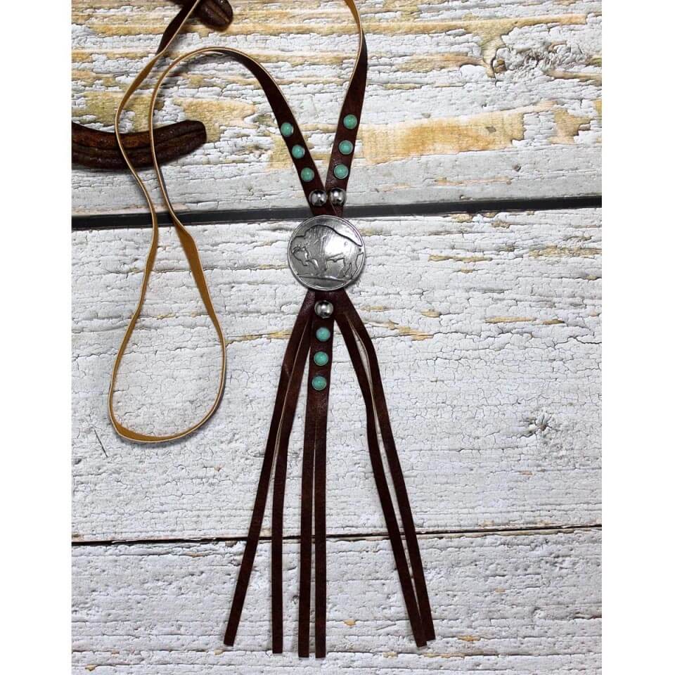 Western Boho Chic style necklace. Modern and different from your average necklace. This 53" long leather strap is 3/8" wide and accented with turquoise rivets. Fringe hangs from the 1-5/8" diameter Buffalo concho. Layer it with shorter necklaces or alone as it makes a statement all by itself.