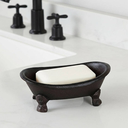 Black cast iron soap dish with a bar of soap on a white bathroom counter.