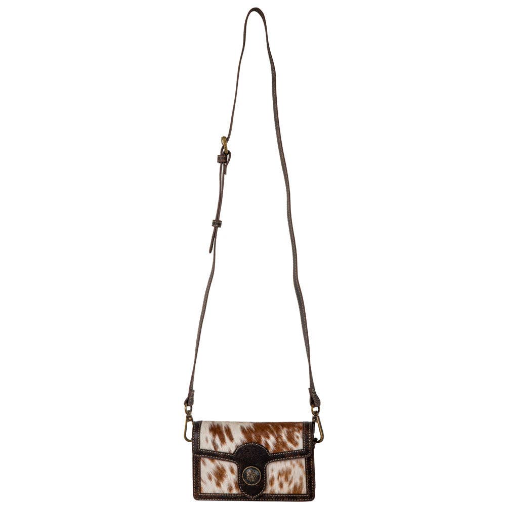 Small crossbody bag with brown and white cowhide pattern on a white background